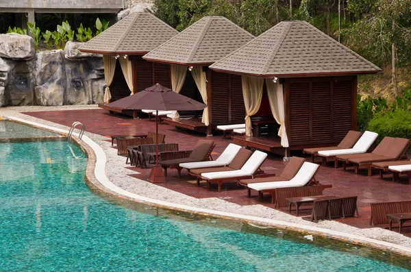 Bella piscina, sedia e capanna in località tropicale — Foto Stock
