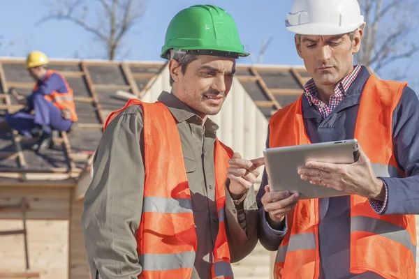 Foreman och lekman på byggarbetsplats — Stockfoto