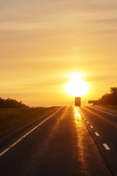 Caminhando ao nascer do sol em uma estrada vazia — Fotografia de Stock