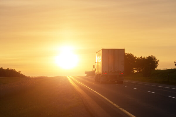 Trucking at sunrise on an empty road