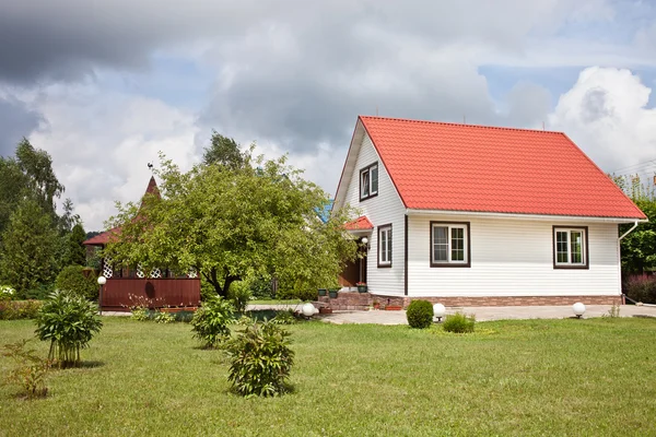 Venkovský dům s červenou střechou a zahrada — Stock fotografie