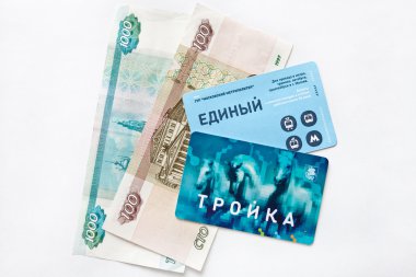 Electronic payment card Troyka for transport and banknotes.Russia.Moscow.February,6,2015. clipart