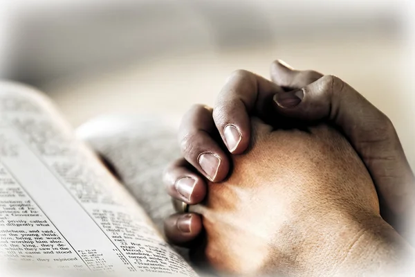 Orando Manos con Santa Biblia y Luz — Foto de Stock