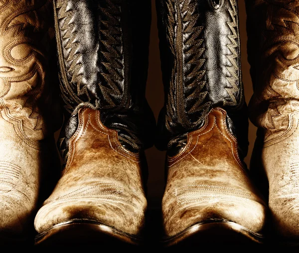 Botas de vaqueiro velho em luz de alto contraste — Fotografia de Stock