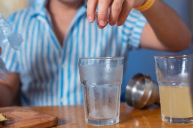 Barmen evde bir kokteyl hazırlıyor. Bardağa buz at.