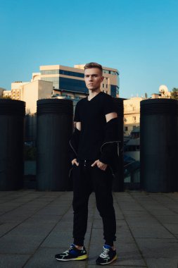 Şık bir adam akşamları şehir ortamında duruyor.