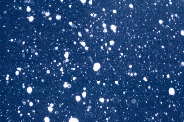 Bulanık. Soyut Noel arkaplanı. Kış tatili dokusu. Kar yağışı. Yağan kar.