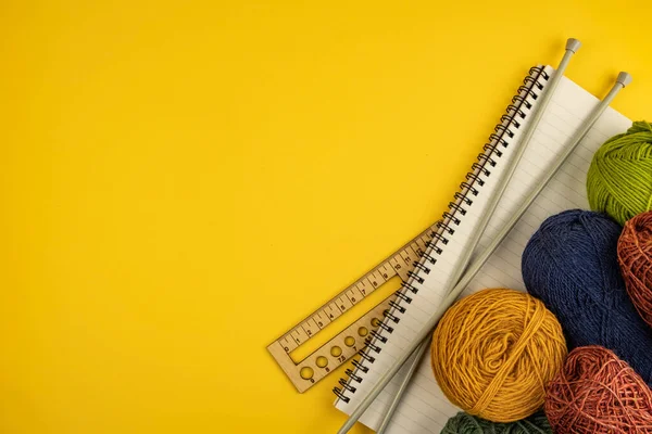 Filati per maglieria, ferri da maglia, taccuino su fondo giallo — Foto Stock