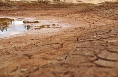 Kurumuş bir gölün dibindeki çatlak arazi.