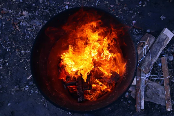 Bovenaanzicht van een oranje vlam in een oud ijzeren vat — Stockfoto