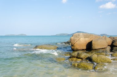 Gün batımında dalgalı denizde taş.