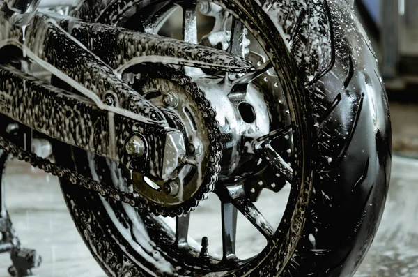 Wash the motorbike at the car wash shop. Foam car wash on wheels