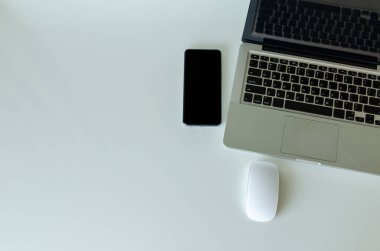 Bilgisayar dizüstü bilgisayarı, akıllı telefon ve fare arkaplanda. Boşluğu kopyala