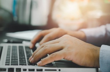 Evdeki masadaki bilgisayarı kullanan adam el bilgisayarı kullanıyor, internetten bilgi arıyor, evden çalışıyor. İş kavramı