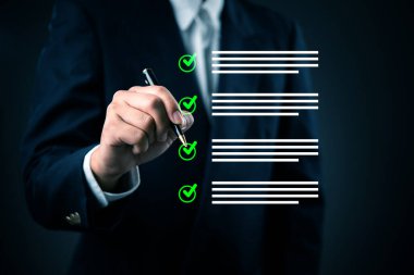 Takım elbiseli adam sanal kontrol listesini tamamlıyor, iş başarısı, hedef başarısı. Görev yönetimi, kalite güvencesi, stratejik planlama, kurumsal sorumluluk ve güvenilir sonuçlar.