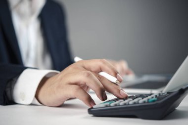 İş adamı el çabukluğu hesap makinesi tuşları, vergi hazırlama, analiz ve iş yatırımı mali muhasebe iş akışı.