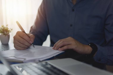 İş adamı masa başında resmi bir belge yazıyor ya da imzalıyor, sözleşme veya anlaşma, onay ve resmi evraklar. ticari hukuki süreçler kavramı.