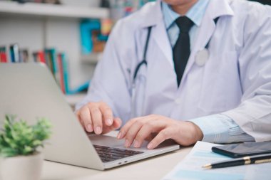 Klinikte bilgisayarda yazma, hasta raporunu inceleme, dijital sağlık yönetimi, hastane kayıt sistemi, çevrimiçi danışmanlık ve teletıp teknolojisi..