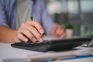 Hesap makinesinin finans verilerini hesaplayan muhasebeci, iş belgeleri, denetim raporu, para yönetimi, vergi sezonu, yatırım analizi, bürodaki evrak işleriyle mali planlama.