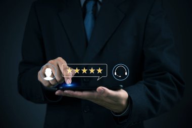 Geri bildirim, takım elbiseli CSAT çalışanı hizmet deneyimini değerlendirmek için cep telefonundan beş yıldız seçer, olumlu tanıklığı, sadakati ve müşteri deneyimi kavramını vurgular.