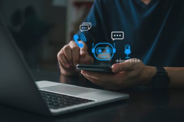Chatbot, destekçi kişi, sohbet baloncukları, çağrı ve mikrofon simgelerinin bulunduğu bir dizüstü bilgisayarın yanında, müşteri hizmetleri otomasyonunu ve her şeyi vurgulayan bir yapay zeka asistanıyla iletişime geçmek için akıllı telefon kullanır..