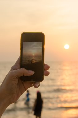 gün batımında el telefon