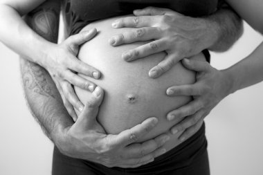 Genç hamile çift kucaklayan