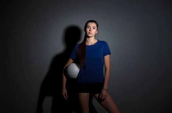 Volleyballmädchen Halten Und Kicken Ball Blauen Kostüm Auf Dunklem Wandhintergrund — Stockfoto