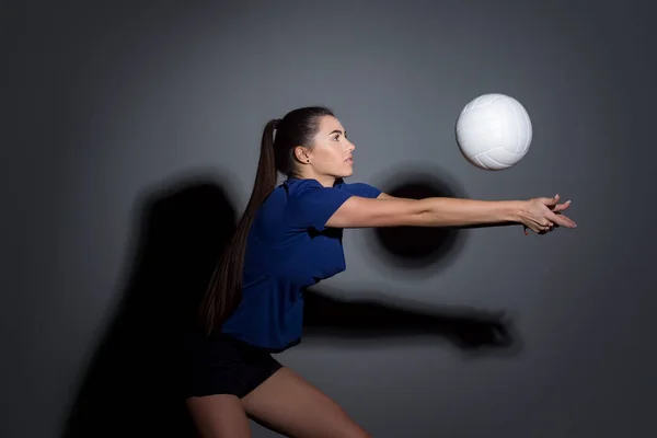 Volleyballmädchen Halten Und Kicken Ball Blauen Kostüm Auf Dunklem Wandhintergrund — Stockfoto