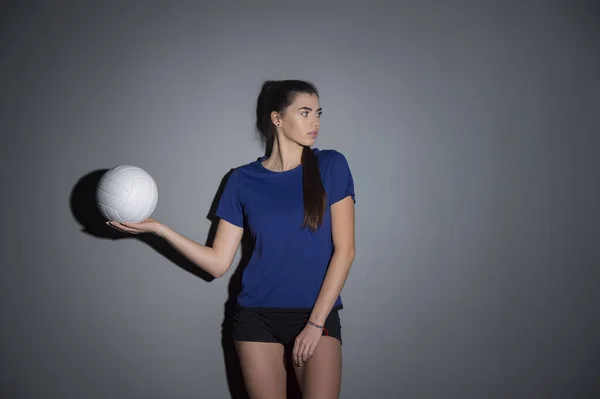 Volleyballmädchen Halten Und Kicken Ball Blauen Kostüm Auf Dunklem Wandhintergrund — Stockfoto