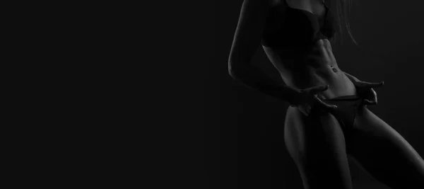 Young woman in underwear on black background. Fitness, diet, skin and body care. Black and white color filter — Stok fotoğraf