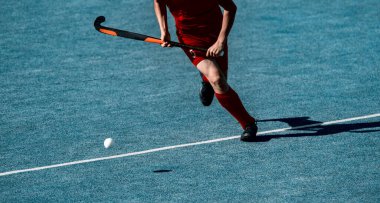 Saha hokeyi oyuncusu, topu takım arkadaşına paslamaya hazır.