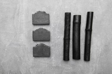 Siyah bambu kömürü ve gri arkaplanda bambu kömürü olan siyah sabunlar..