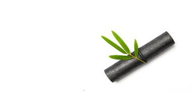 Bambu etkinleştirilmiş kömür çubuğu ve yeşil yaprak beyaz arkaplanda izole.. 