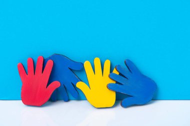 Mavi arka planda renkli yapboz elleri. Dünya Otizm Farkındalık Günü Kavramı