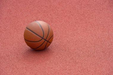 Spor salonunun kahverengi sahasında turuncu basketbol. Sokak basketbolu
