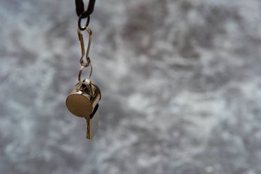 Gri arka planda spor düdüğü. Kavram - spor müsabakası, hakem, istatistik, meydan okuma. Basketbol, hentbol, futsal, voleybol, futbol, futbol, futbol ve hokey hakemi düdüğü.