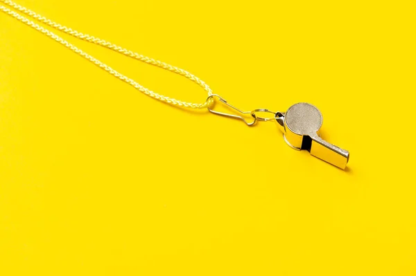 Sports whistle on yellow background. Concept - sport competition, referee, statistics, challenge. Basketball, handball, futsal, volleyball, soccer, baseball, football and hockey referee whistle