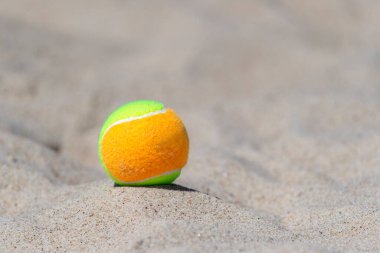 Kumsalda kumsalda tenis topu. Yaklaş.