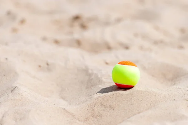 Tennis ball on the sand at the beach close up. Professional sport concept