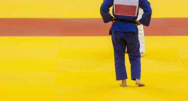 Beyaz ve mavi üniformalı iki judo dövüşçüsü. Yatay spor posteri, tebrik kartları, başlıklar, web sitesi