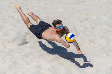 Profesyonel plaj voleybolcusu topu alıyor. Yatay spor posteri, tebrik kartları, başlıklar, web sitesi