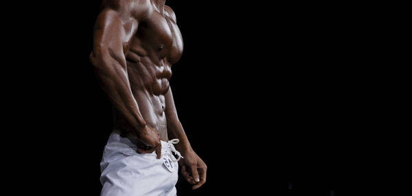 Athlete bodybuilder in white summer shorts at competitions in beach bodybuilding. Black and white filter. Horizontal sport poster, greeting cards, headers, website.