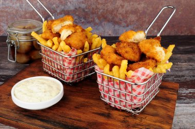 Scampi ve patates kızartması kablo içinde tartar soslu sepet servis ediyorlar.