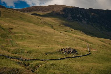 Lake District Ulusal Parkı, Cumbria, Birleşik Krallık 'ta dağ sırasına rağmen kırsal yolun manzarası