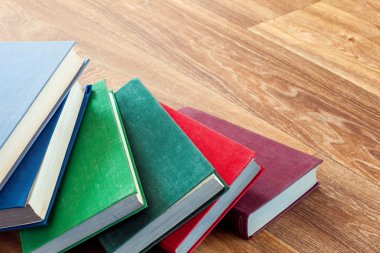 ahşap bir masa üzerinde yalancı çok renkli kitaplar.