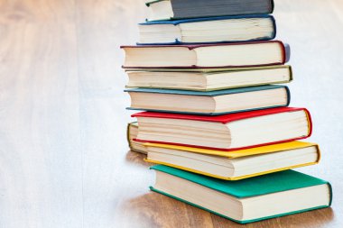 ahşap bir masa üzerinde yalancı çok renkli kitaplar.
