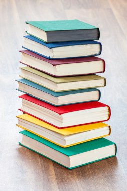 ahşap bir masa üzerinde yalancı çok renkli kitaplar.