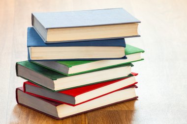 ahşap bir masa üzerinde yalancı çok renkli kitaplar.