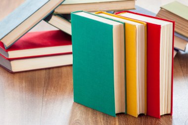 ahşap bir masa üzerinde yalancı çok renkli kitaplar.